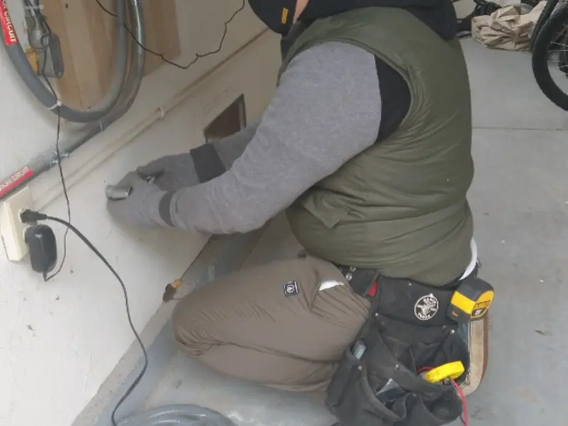 Electrician performing outlet wiring in a Wake Forest garage
